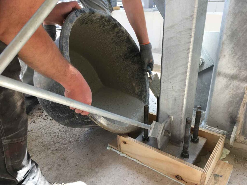 Gieten van gietmortel in een bekisting rondom stalen constructie