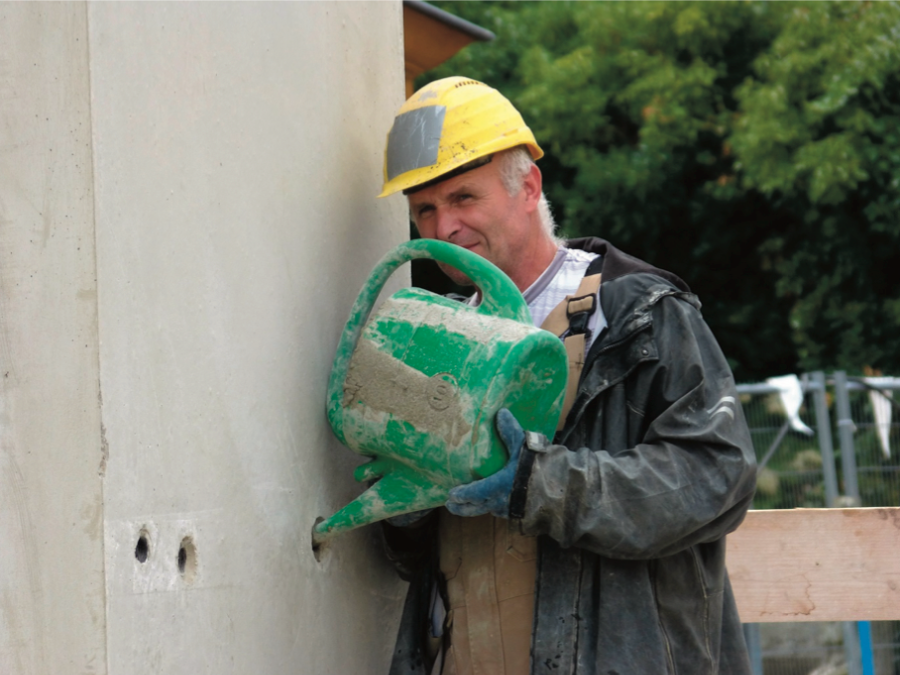 Gieten van gietmortel in een betonnen muur door een vakman